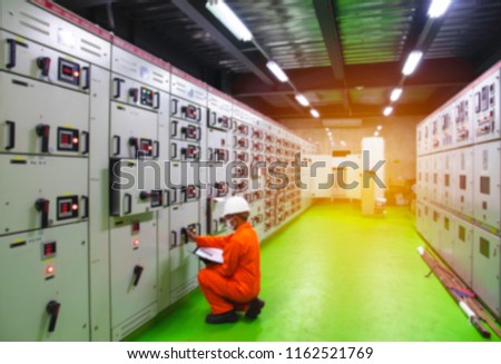 Blurred and Soft focus of Engineer checking and monitoring the electrical system in Electrical switch gear at Low Voltage motor control center cabinet room,Electrical selector switch,button switch.