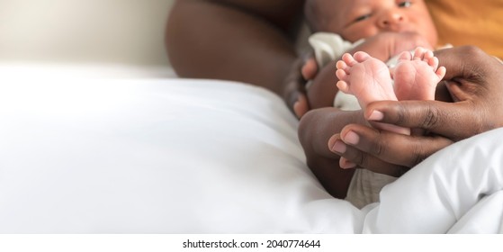 Blurred Soft Images, Hand Of Father Holding  Baby's Foot Of African Black Skin Baby Newborn, Concept To Showing Love And Concern For His Children, And Is Love Family Relationship.