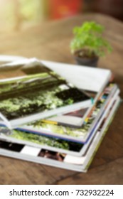 Blurred stack magazines on wood table for background.