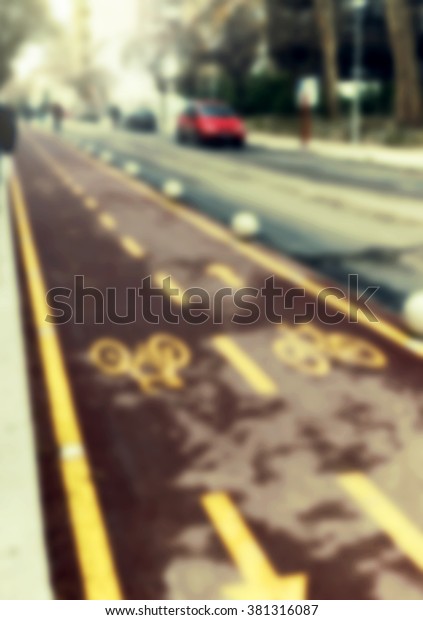Blurred street with bike\
line, people, cars and blurred lights. Blurred street background /\
texture.