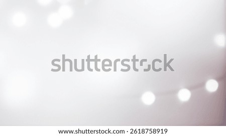Blurred string lights create a soft white and pink abstract background. Bokeh background with bright and shiny light, sophisticated and modern design.