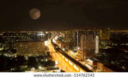 Blurred super moon and city at night with traffic lights in motion