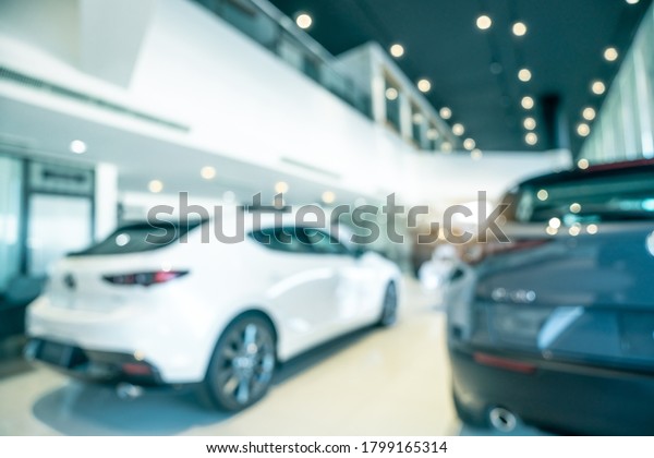 Blurred SUV car parked in modern showroom. Car\
dealership and auto leasing concept. Automotive industry. Modern\
luxury showroom. Rear view new car parked in showroom. Electric\
automobile technology. 