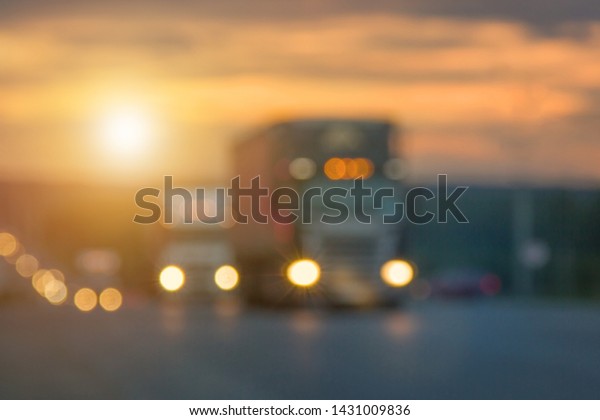 Blurred textures of truck\
traffic with glowing lights on the highway after sunset. Route,\
road, transport.