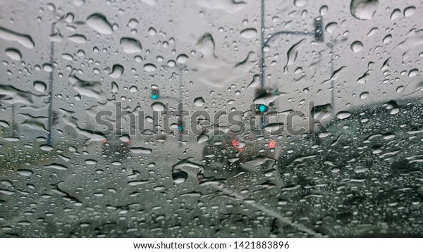 Blurred through car windows with rain drop. Selective\
focus. 