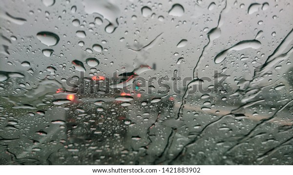 Blurred through car windows with rain drop. Selective\
focus. 