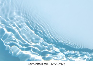 Blurred Transparent Blue Colored Clear Calm Water Surface Texture With Splashes And Bubbles. Trendy Abstract Nature Background. Water Waves In Sunlight With Copy Space.