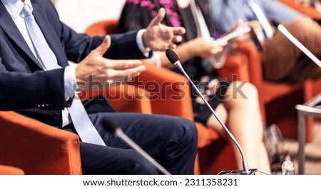 Blurred unrecognizable participants at round table political meeting or international business event or conference