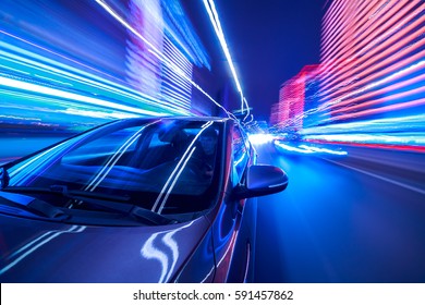 Blurred urban look from fast driving car to back side and driver at winter night. Longexposure shot. - Shutterstock ID 591457862