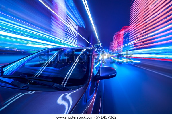 Blurred urban look from fast\
driving car to back side and driver at winter night. Longexposure\
shot.