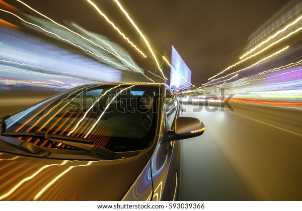 Blurred urban look from fast\
driving car to back side and driver at winter night. Longexposure\
shot.