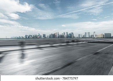 blurred urban traffic road with cityscape in background, China