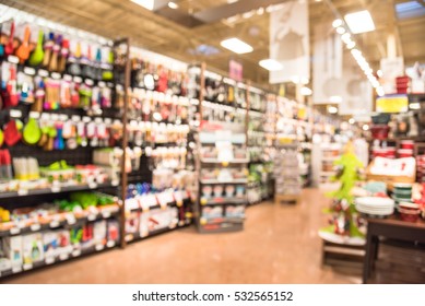 Blurred Variety Of Kitchen Utensils And Colorful Plates, Bowls And Cups Of Every Shape And Size Fill The Shelves Display At Store In Texas, US. Kitchen Hand-held Tools And Gadget Necessities