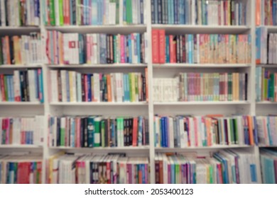 Blurred Variety Many Books Stands On Wooden Shelves Of Bookcase In Library Or Bookstore Front View Out Of Focus