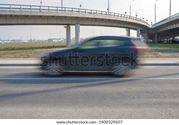 Blurred vehicles moving on the road, sunny\
day, cityscape\
background