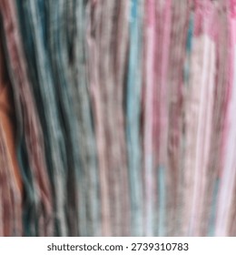 Blurred vertical stripes of multi colored fabric create an abstract soft texture background for creative design and artistic backdrops.