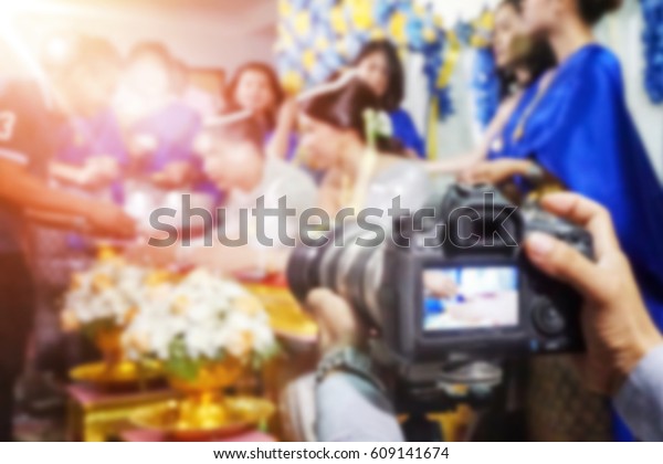 Blurred Video camera operator working while\
filming background
