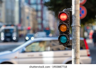 blurred view of city traffic with traffic lights, in the foreground a traffic light with a red light