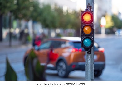blurred view of city traffic with traffic lights, in the foreground a semaphore with a red light