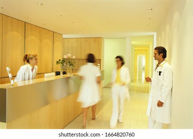 Blurred View Of Doctors Passing In And Out Of Office Setting