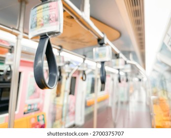 Blurred view of an empty subway train interior with bright yellow seats and stainless steel poles. The modern train car is well-lit, featuring overhead handles and smooth, clean floors