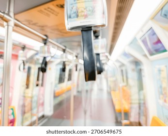 Blurred view of an empty subway train interior with bright yellow seats and stainless steel poles. The modern train car is well-lit, featuring overhead handles and smooth, clean floors,