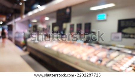 blurred view of fresh fish seafood displayed in iced shelves in supermarket, retail store. raw fish ready for sale in the shopping mall, defocused.