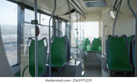 Blurred view inside an empty bus interior showcasing green seats and sunlight filtering through windows, creating a soft, defocused atmosphere with an indoors tranquility.