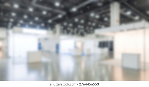 Blurred view inside a large empty exhibition hall featuring minimalist architecture and professional lighting for business events