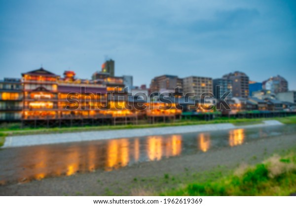 Blurred view of Kyoto skyline along the city river\
at night.