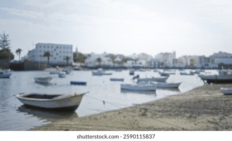 Blurred view of lanzarote harbor with boats on calm water and buildings in the background under a clear sky in canary islands spain - Powered by Shutterstock - Get 15% off with code: PIKWIZARD15