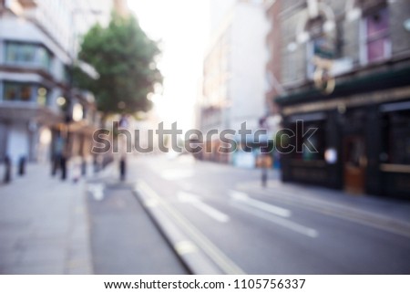 Blurred view of London street with shops, trees and buildings. Can be used as background 
