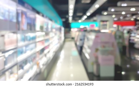 Blurred View Of Modern Beauty Salon Interior. Different Cosmetics Products Displayed On Shelves. Blurred Image Of Cosmetic Shop. Cosmetic Shop Background.