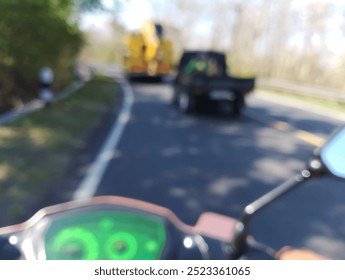 Blurred view of a motorcycle dashboard with a digital speedometer and tachometer. The background is blurred, showing a road and other vehicles. - Powered by Shutterstock