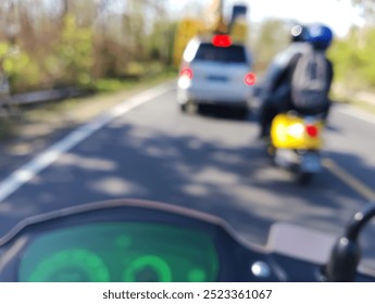 Blurred view of a motorcycle dashboard with a digital speedometer and tachometer. The background is blurred, showing a road and other vehicles. - Powered by Shutterstock