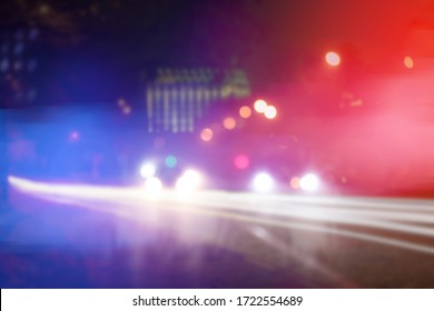 Blurred view of police cars on street at night - Shutterstock ID 1722554689
