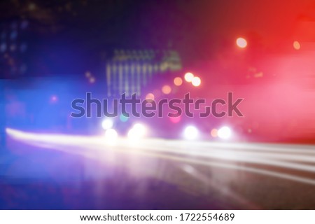 Blurred view of police cars on street at night