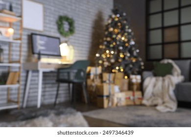 Blurred view of programmer's office with workplace, Christmas tree and glowing lights