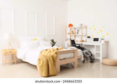 Blurred view of student's bedroom with wheelchair and table - Powered by Shutterstock