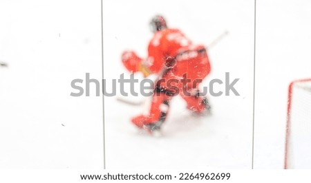 blurred view through protective safety glass. hockey goalie on the ice of the winter stadium, background