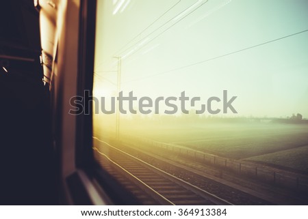 Blurred vintage filtered countryside view by a train window - travel, transport, journey concept