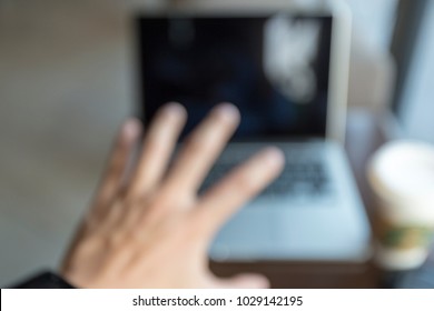 Blurred Vision Of Hand Reached To Laptop With Coffee Near Window