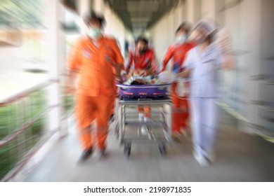 Blurred Vision Of Staff Moving A Patient On A Stretcher
