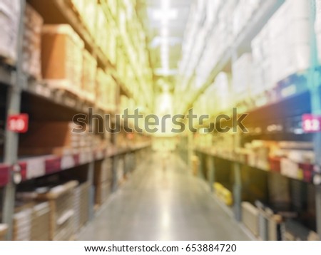 Blurred warehouse or storehouse with The boxes on high shelves stocked. Motion blur effect. Bright sunlight as background.