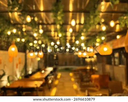 Blurred warm bokeh lights of an empty outdoor cafe or restaurant patio at night