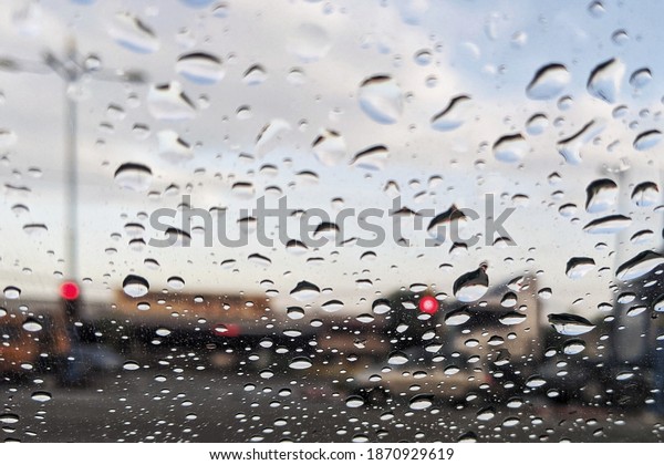 Blurred water droplets on the windscreen. Blurred\
water droplets on the\
glass.