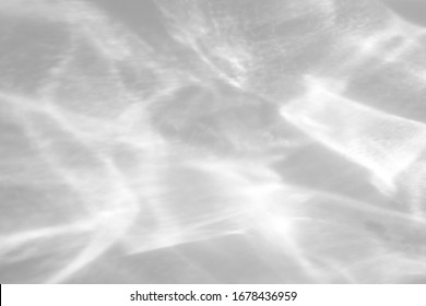 Blurred water texture overlay effect for photo and mockups. Organic drop diagonal shadow and light caustic effect on a white wall.