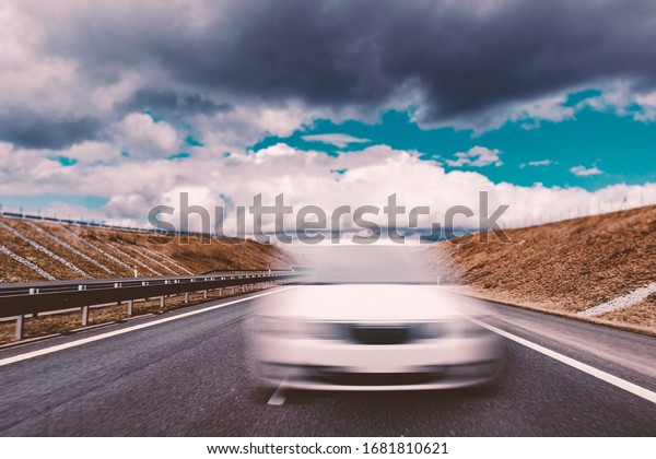 Blurred White Car\
on European Asphalt\
Highway