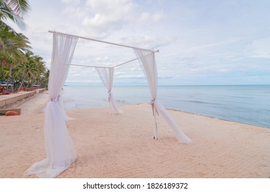 Blurred White Wedding Arch At Beachfront Resort In Thailand.