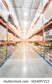 Blurred wholesale store aisle with big boxes of product from floor to ceiling racks. Large warehouse wholesale in America. Defocused industrial distribution storehouse abstract background